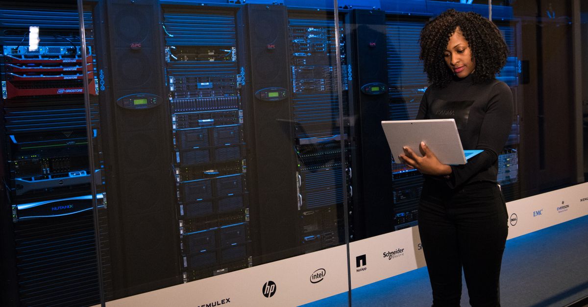 Engineer reviewing infrastructure monitoring dashboards at server rack